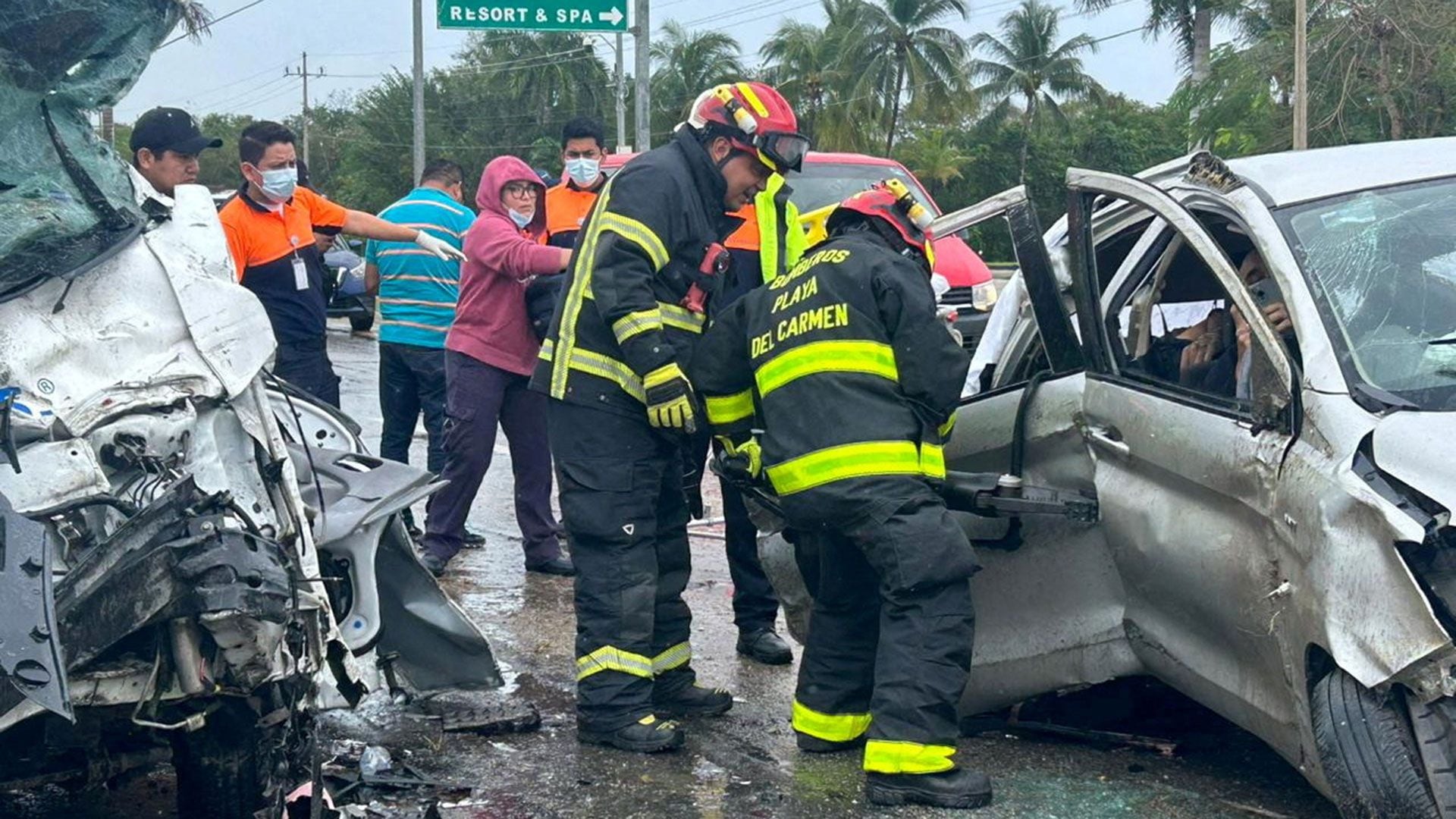 Playa del Carmen firefighters work at the accident site where a truck and a van collided on the Playa del Carmen-Tulum highway