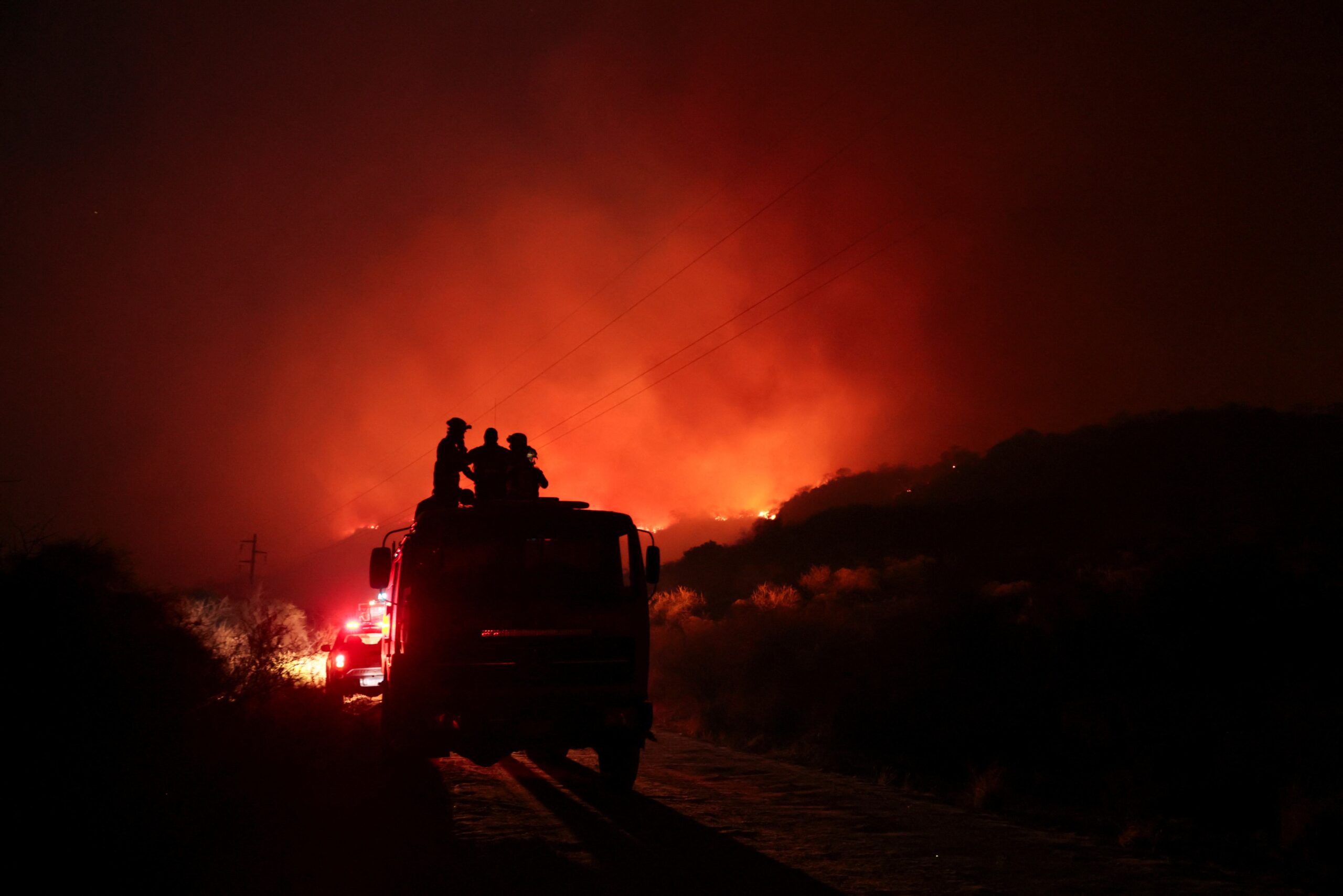 Un equipo de bomberos que trabajó durante la noche para combatir las llamas en San Marcos Sierra (REUTERS)